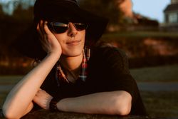Dreaming stylish woman in sunglasses and hat