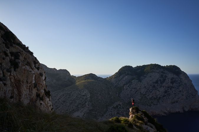 Unrecognizable traveler standing on mountain peak