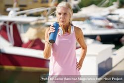 Mature sportswoman drinking between exercise 0Krazb