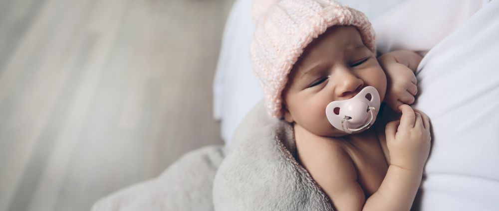Baby girl with pacifier sleeping