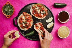 Crop hand holding taco al pastor