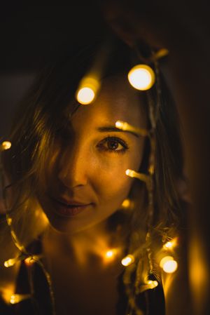 Woman surrounded with light garland