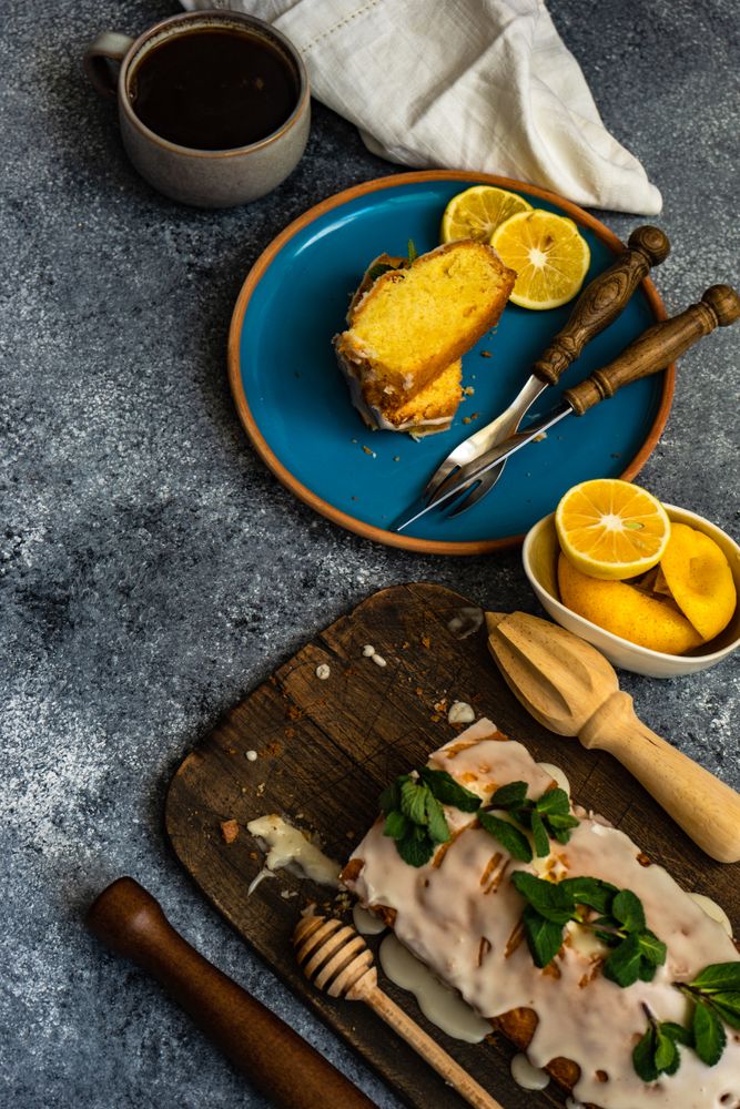 Delicious lemon cake with fresh mint served on blue plate with coffee
