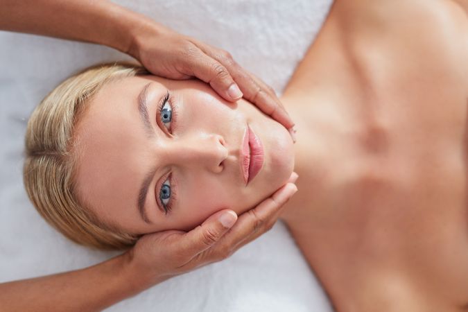 Blonde woman looking up during facial treatment