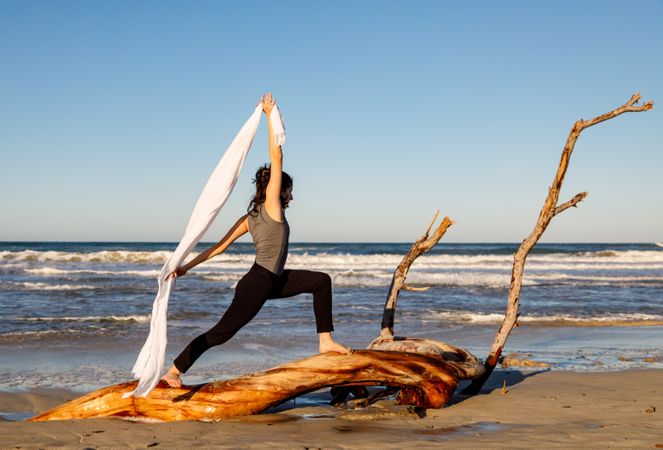 Young woman dancing and posing near water on shore