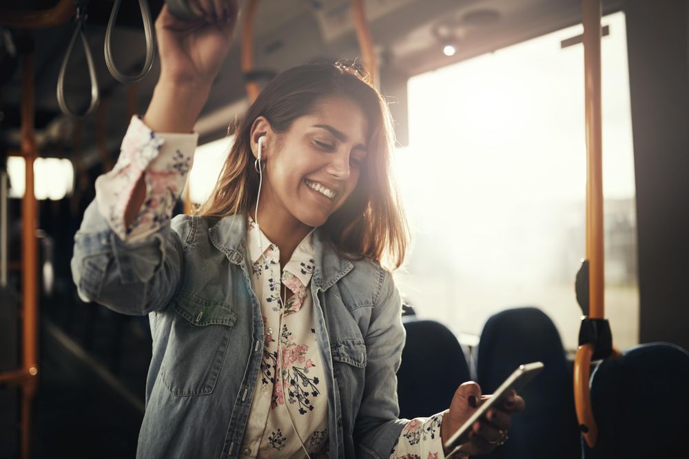 Woman smiling at phone on bus