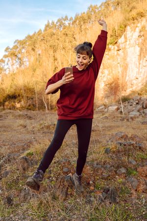 Young woman with smartphone dancing