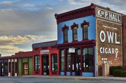 A classic Owl Cigar advertising sign dominates a block of Socorro, New Mexico