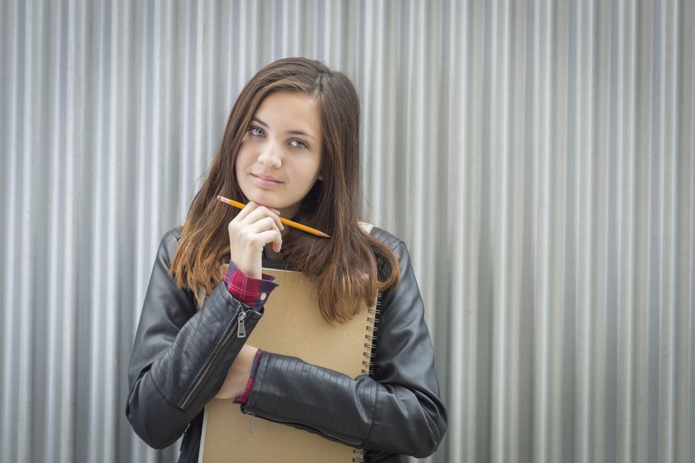 Melancholy Female Student With Books Looking to the Side