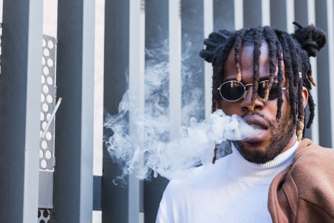 Hipster Black man with electronic cigarette on the street