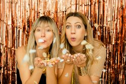 Charming women with confetti on party