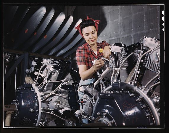 Long Beach, CA, USA - 1942: Woman working on an airplane motor at North American Aviation
