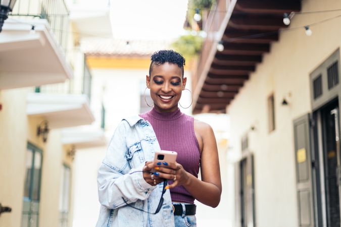 Cool Latin American woman using smartphone in the city