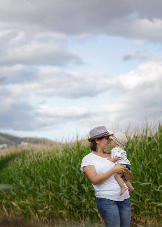 Adorable mother and child on hand enjoying and laughing in field