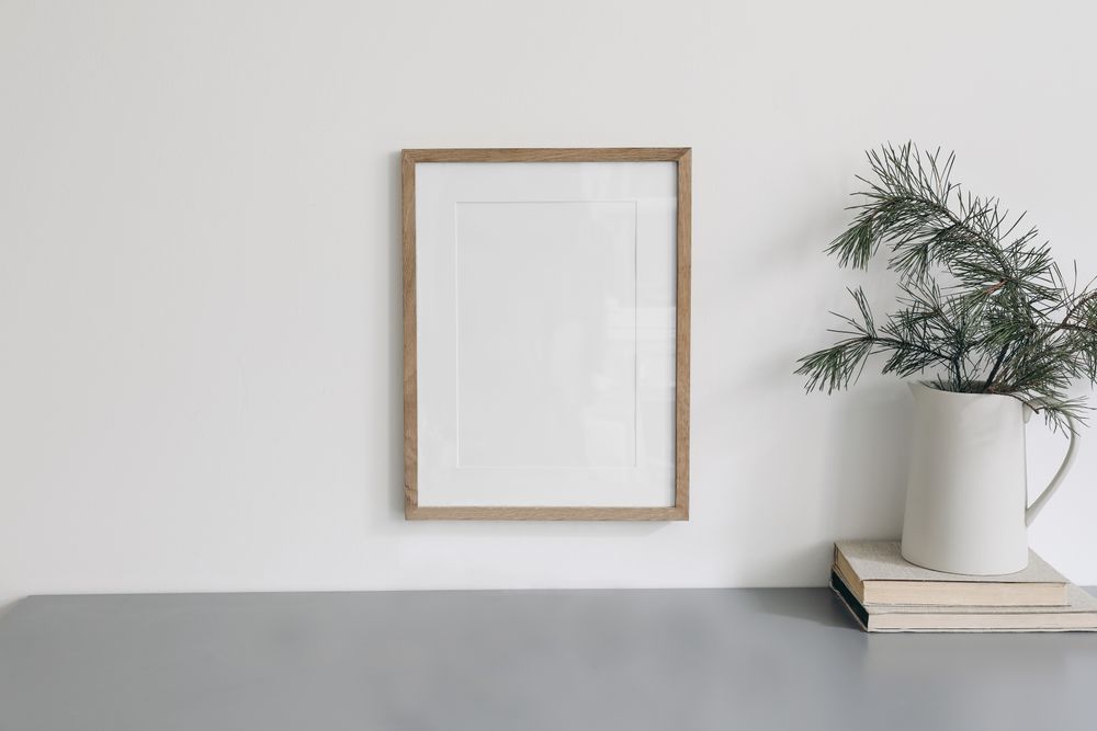 Wooden frame hung above desk with branches and books