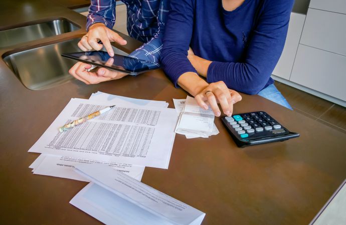 Woman and man reviewing their monthly bills on kitchen counter