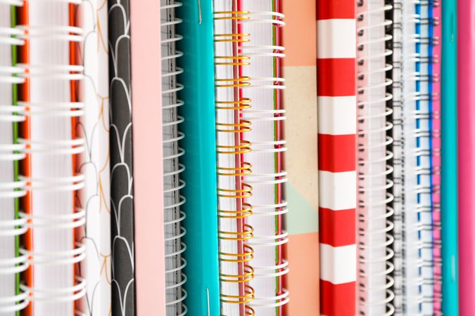 Stack of colorful books and copybooks as background, closeup