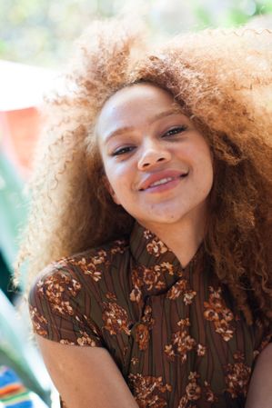 Close up portrait of happy young woman outdoors smiling at camera