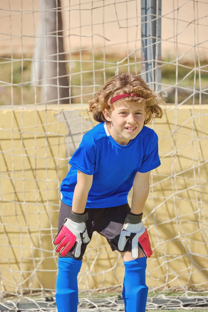 Kid standing at football goal