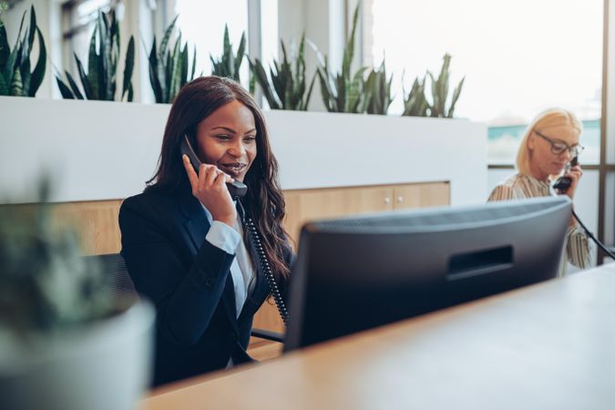 Two woman on the phone at the front desk