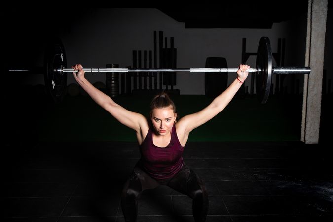 Woman lifting barbell in gym