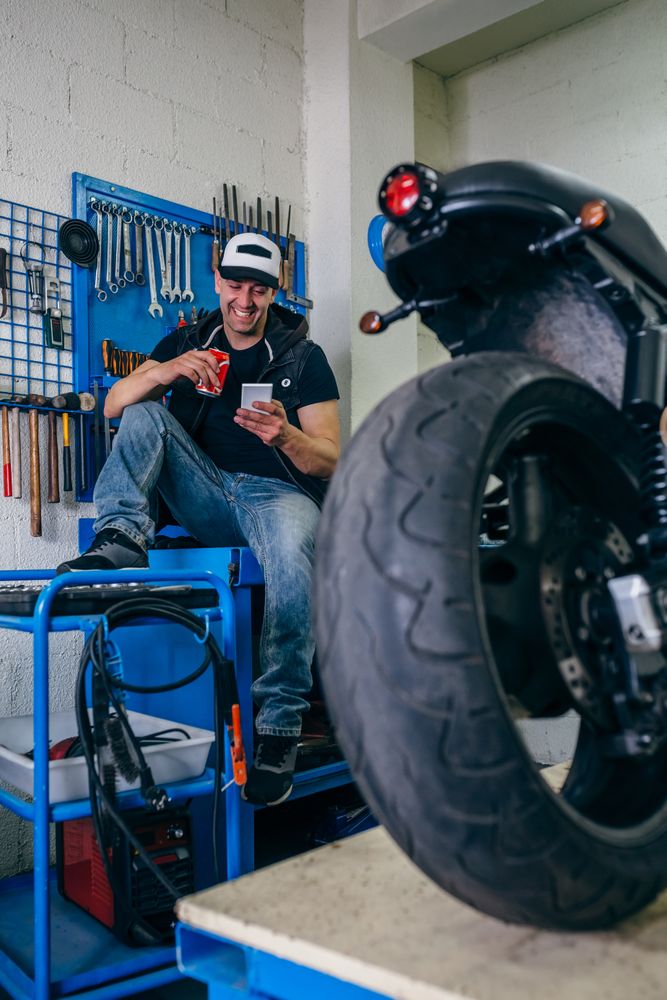 Motorcycles mechanic resting having a beer