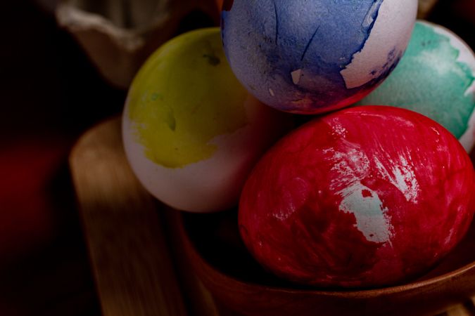 Set of painted Easter eggs in container on table
