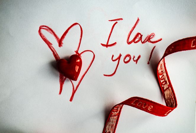 Valentine Day holiday concept with "I love you" written on paper with ribbon and heart ornament