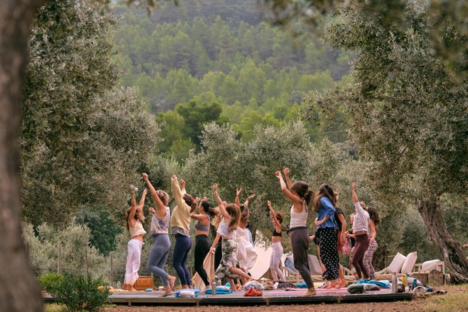 Group of women dancing with raised hands during aerobic class