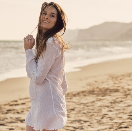 Young woman at the beach at sunset