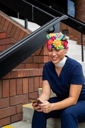 Nurse on break sitting on steps in front of medical building taking break looking at phone