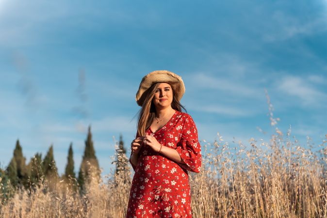 Happy dreamy woman standing among high grass