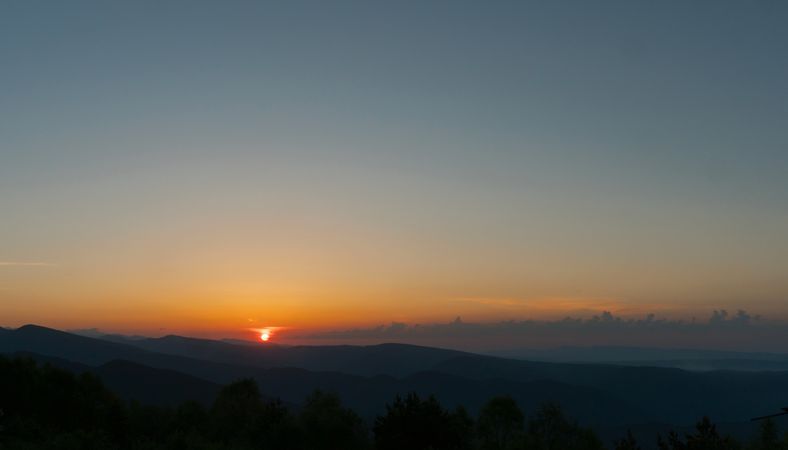 Setting sun over a mountainous landscape