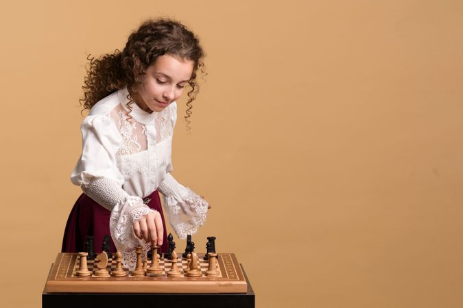 Young girl concentrating while moving chess piece