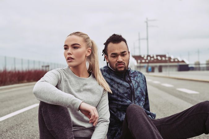 Beautiful couple resting from morning run on country road