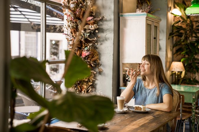 Cheerful woman talking on phone in cafe