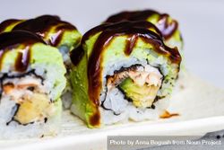 Close up of sushi rolls with avocado and eel sauce 47mkdB
