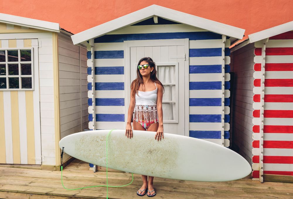 Female surfer with top and bikini holding surfboard