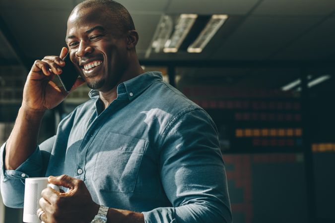Happy businessman making a phone call in office