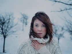 Dreamy woman in sweater against winter landscape