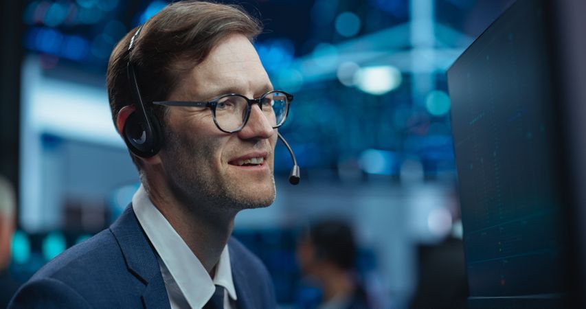 Adult Man Wearing Glasses and Headphones, Researching Investment Possibilities for International Business Corporations