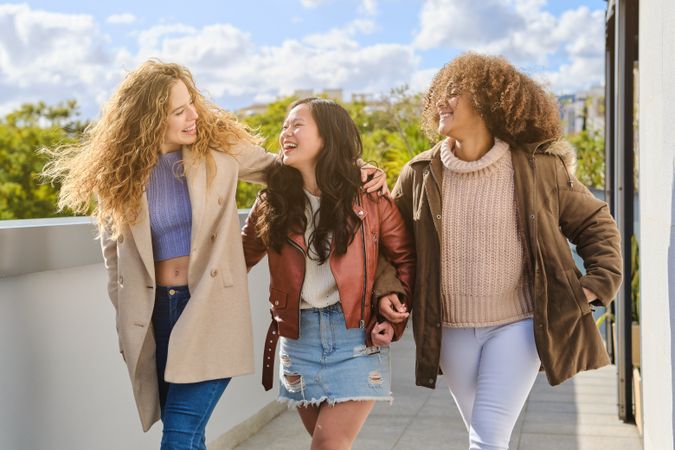 Multiethnic friendly women walking on terrace