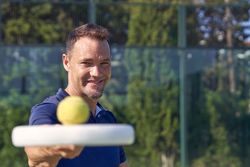 Cheerful man with racket and ball