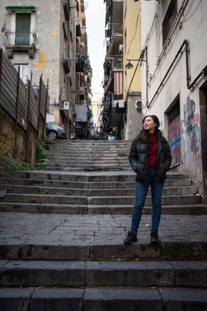 woman standing on steps on shabby street