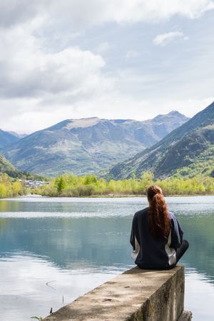 Carefree traveling woman enjoying freedom near lake in mountains