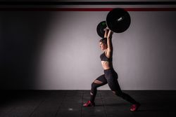 Woman lifting barbell in gym