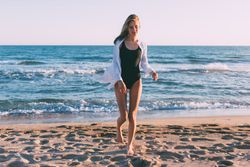 Woman in bathing suit walking out from the ocean