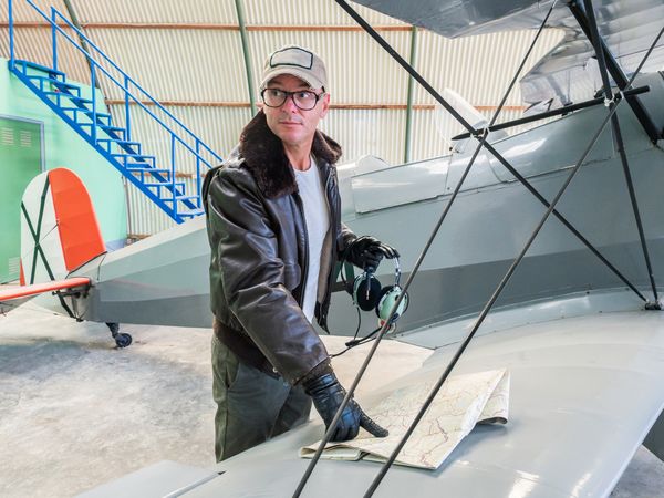 Pilot with map beside small plane