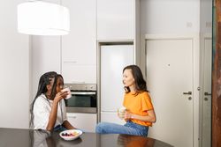 Two women chatting over breakfast in the kitchen