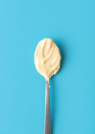 Light chocolate spoon above view on a blue background